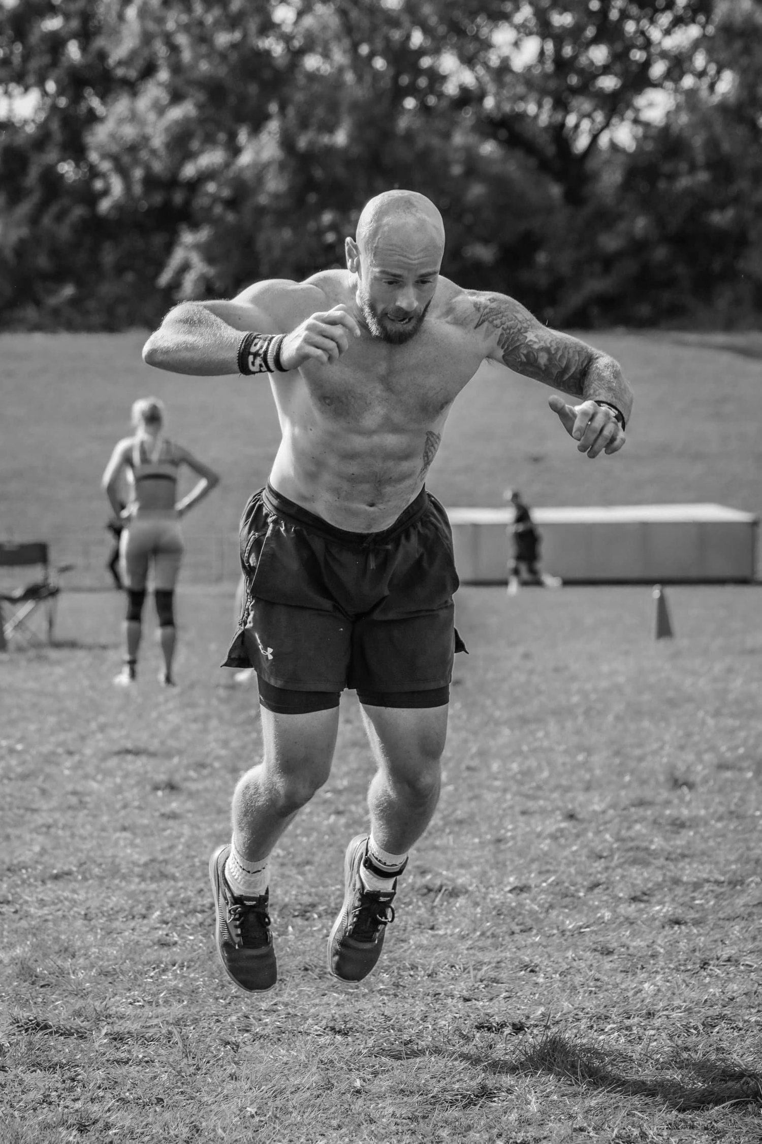 Atleta a realizar um salto em comprimento a meio de um burpee na pista de 30 m