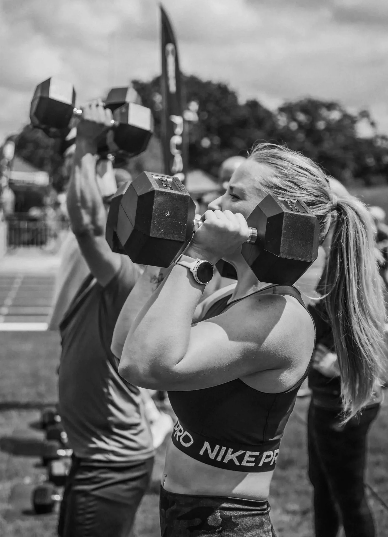 Atleta a levantar dois halteres acima da cabeça no exercício «Push Press»